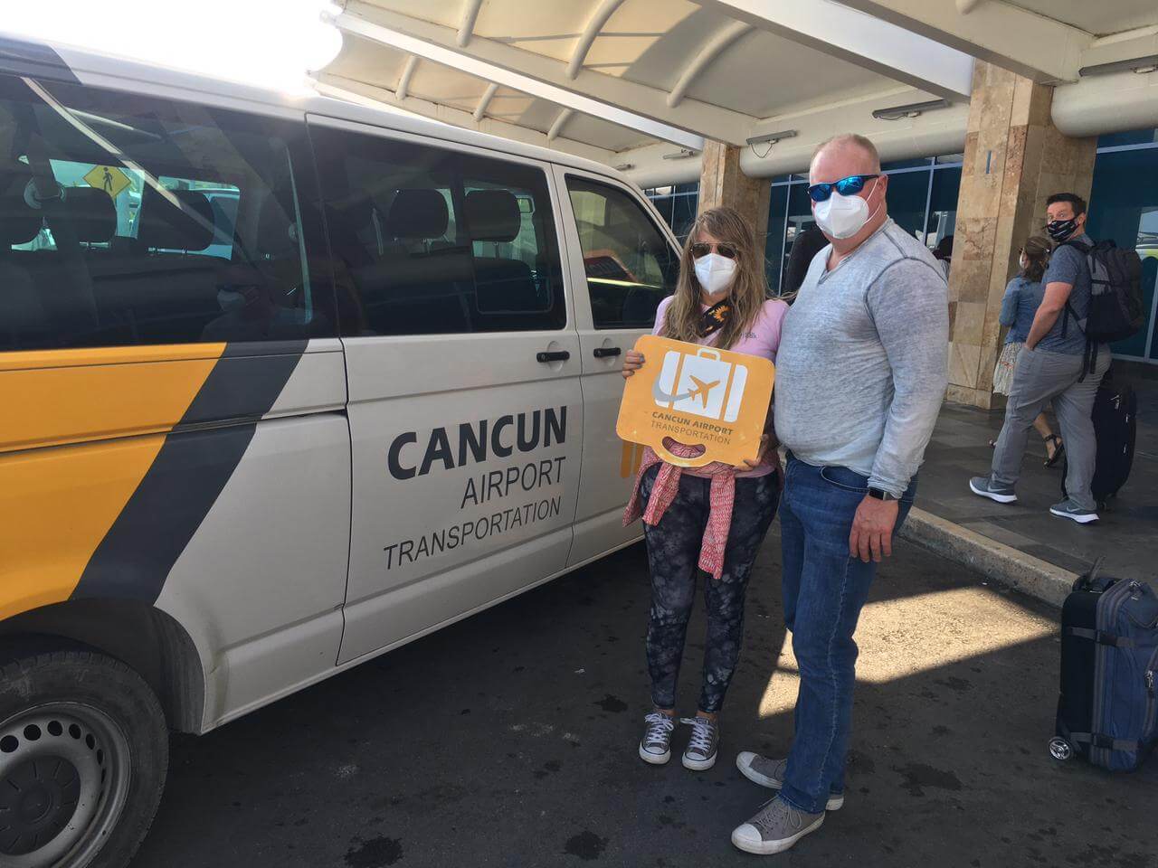 Dos clientes usando máscaras en el Aeropuerto de Cancún después de un servicio de Transporte Privado