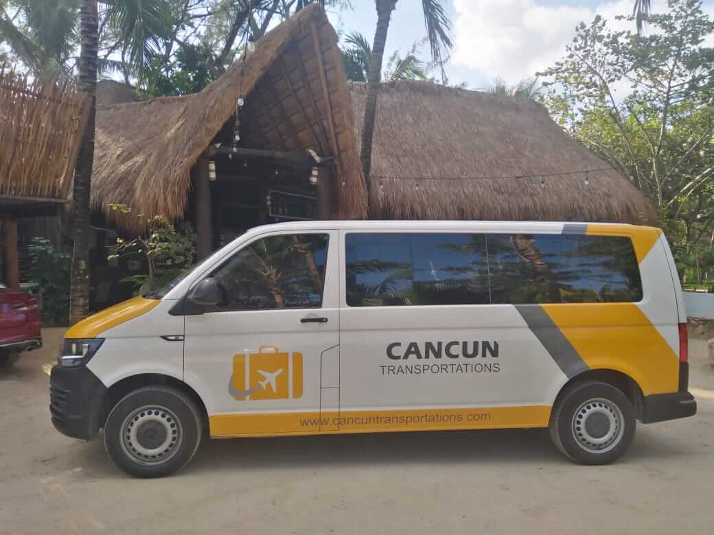 Van parked in front of palapa-roofed hotel lobby