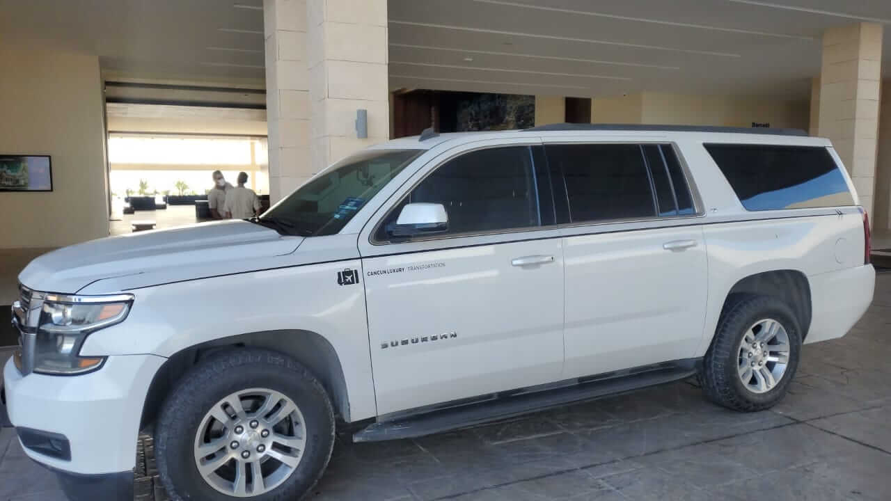 White Suburban parked in front of hotel lobby