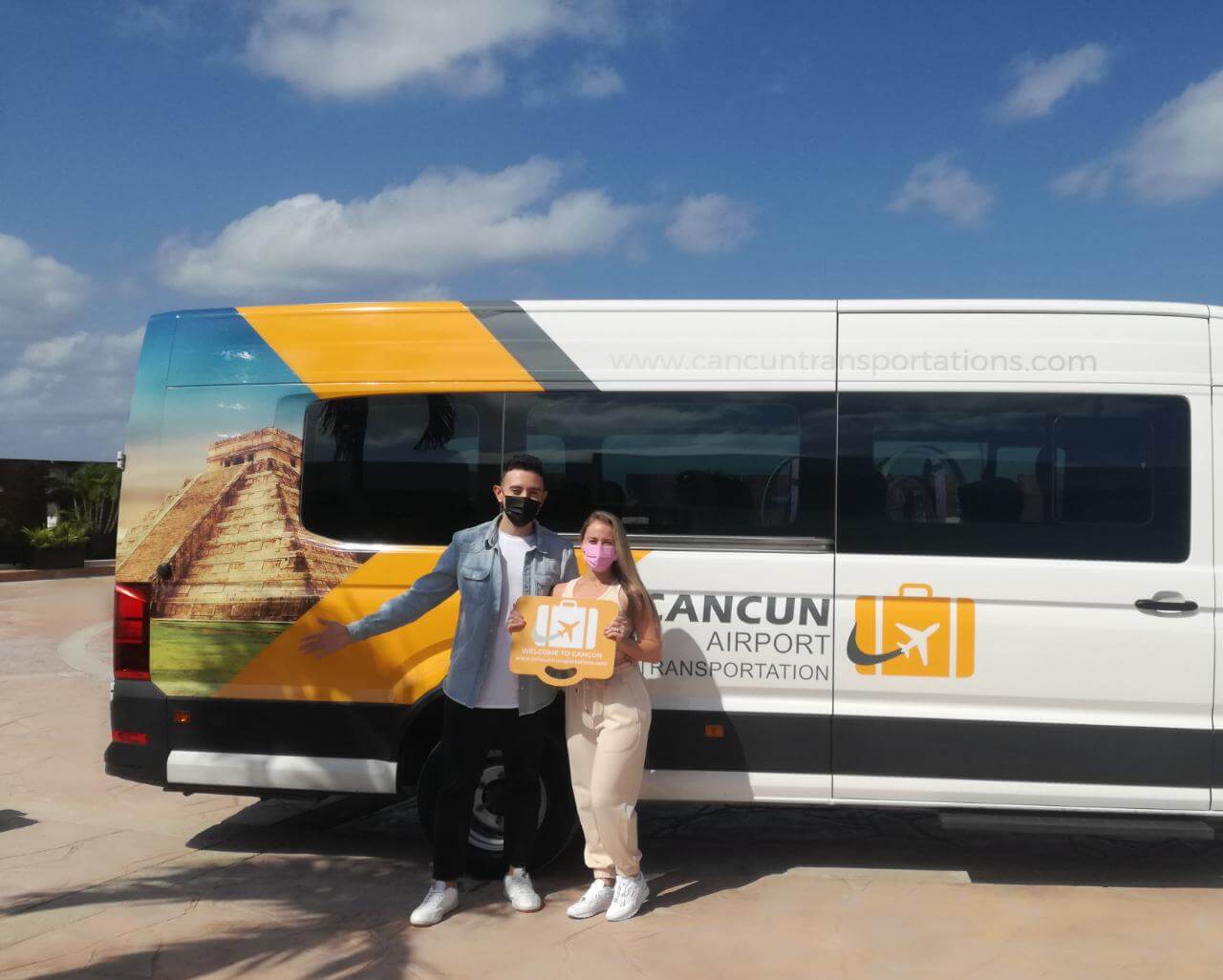 Pareja sosteniendo paleta con logo después de un servicio de Transporte para Grupos