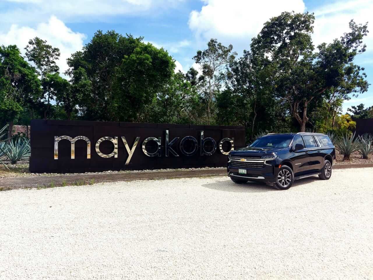 Luxury black SUV parked by Mayakoba sign